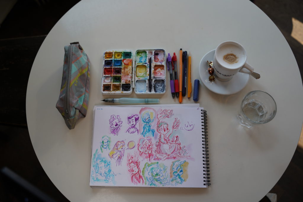 Kit de dessin: une table, des crayons et un café.